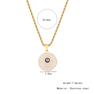 Detail of gold Hamsa hand pendant with blue evil eye on stainless steel chain necklace