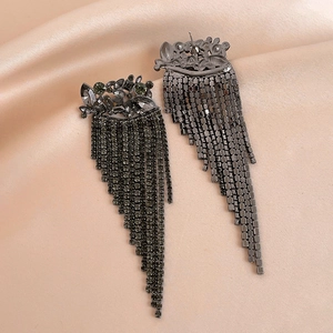 Detailed macro view of gunmetal tassel earrings with black faceted gemstones and bead chains