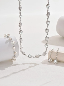 Detailed view of silver wedding jewelry set with pearls and rhinestones on geometric stands
