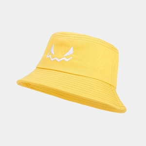 Close-up of yellow cotton bucket hat featuring high-quality white monster face embroidery