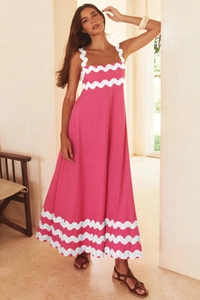 Detail of a pink maxi dress with white wavy trim and elegant cotton-linen texture