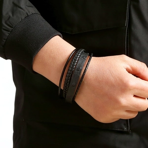 Close-up of a men's multilayer braided black leather bracelet with rivet details on wrist