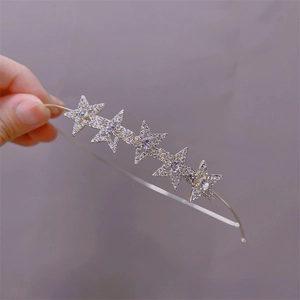 Macro detail of a silver headband featuring five sparkling rhinestone star ornaments