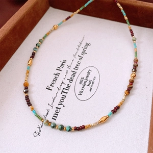 Macro view of vintage beaded necklace featuring turquoise, tiger eye, and metal accents