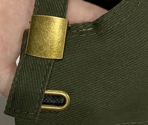 Détail de la boucle réglable en bronze sur la casquette de baseball en coton vert