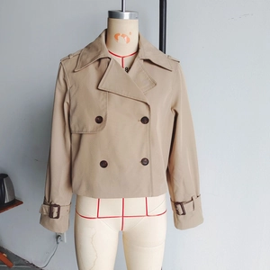 Gros plan détaillé du trench-coat court kaki à double boutonnage et col classique