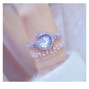 Detail shot of women's silver quartz watch with diamond bezel and crystal accents on wrist