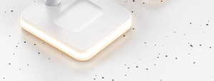 Close-up of 3-in-1 magnetic wireless charger base with warm LED ring light detailing
