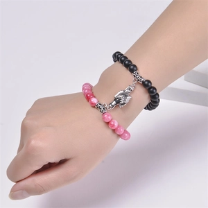 Natural stone bead magnetic couple bracelets with hand-holding charms on model's wrist