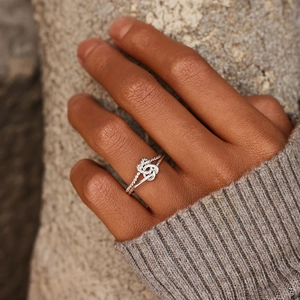 Close-up of s925 sterling silver double knot open ring worn on a finger