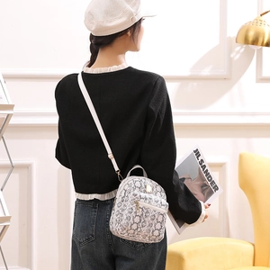 Model view of small snakeskin pattern backpack with adjustable white shoulder straps