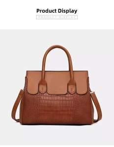 Detail view of brown tote with crocodile pattern texture and adjustable shoulder strap