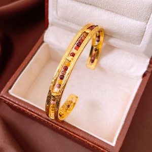 Detailed macro view of gold plated cuff bangle with multi-colored bead inlay