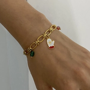 Detail view of a gold chain bracelet featuring festive snowflake glove enamel charms and beads