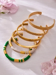 Detail of five-piece stacked bangle set with colorful enamel and golden metal textures