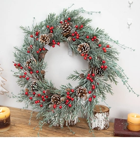 Christmas wreath with red berries, pine needles and snow effect on vintage wood surface