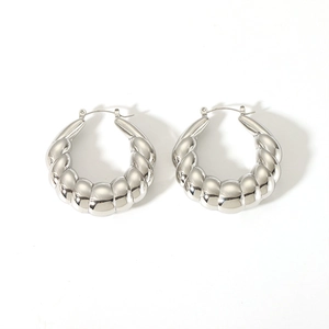 Detail shot of silver twisted hoop earrings with a chunky hollow croissant-style texture