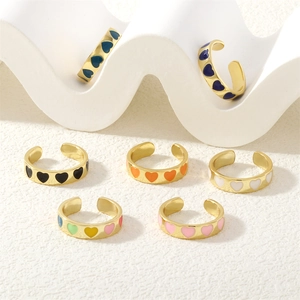 Close-up of golden adjustable open rings with colorful heart-shaped enamel patterns