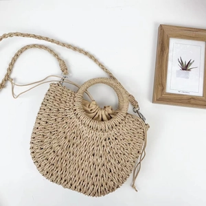Handmade straw bucket bag with round handles and drawstring lining in beige