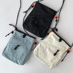 Detailed shot of multi-color nylon messenger bags with adjustable cords and orange accents