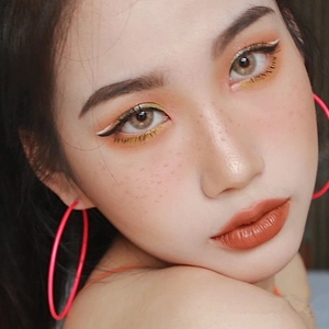 Gros plan de grandes créoles roses au fini gomme portées par un mannequin chic