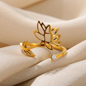 Macro shot of gold hollow lotus ring with sparkling zircon on beige silk fabric