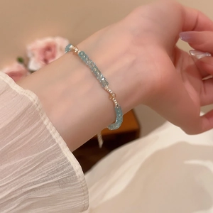 Detail of light blue crystal beaded bracelet on wrist with adjustable metal extension chain