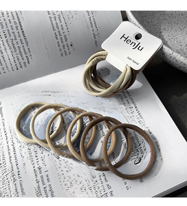 Detail of high-elastic seamless hair ties in earth tones on vintage book background