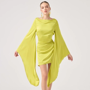 Detail of yellow satin dress featuring oversized flare sleeves and asymmetric draped hem