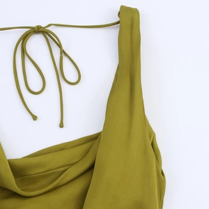 Detail of olive green summer dress featuring elegant shoulder tie straps and neckline