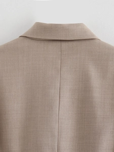 Close-up of the rear neckline and seams of a tan tailored jacket with premium stitching