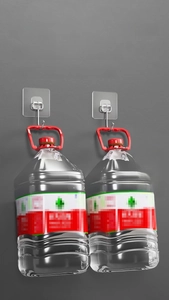 Heavy-duty adhesive wall hook demonstrating a 30kg load-bearing capacity with water jugs