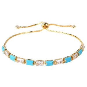 Elegant gold adjustable bracelet with turquoise stones and sparkling zircons on white backdrop