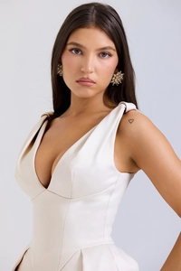 Détail de la robe en satin blanc avec col en V, larges bretelles et boucles d'oreilles