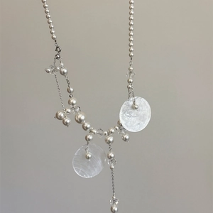 Detail of shell pendant necklace with pearls and crystal beads on silver chain