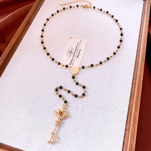 Détail du collier pendentif clé vintage avec pierre brune sur un plateau en bois