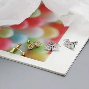 Macro view of gold and silver fan-shaped s925 studs with rectangular zircon stones