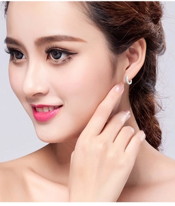 Close-up of a silver pavé hoop earring with sparkling zircons worn by a model
