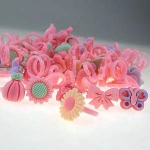 Macro detail of assorted pink resin rings with flower and butterfly cartoon shapes