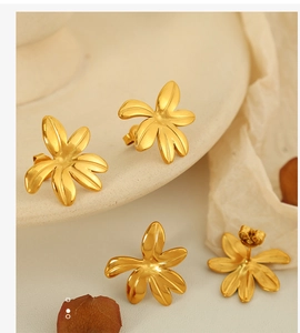 Macro detail of 18K gold plated titanium steel flower earrings with high-polished finish