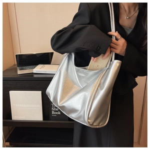 Détail du sac cabas argenté avec texture métallisée sur l'épaule d'un mannequin pro