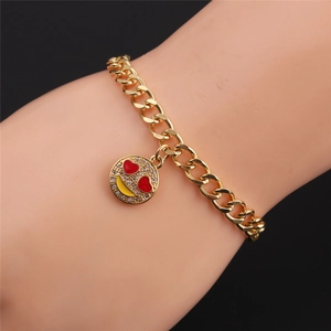 Detail of gold Cuban chain bracelet featuring a sparkling emoji heart-eye smiley charm
