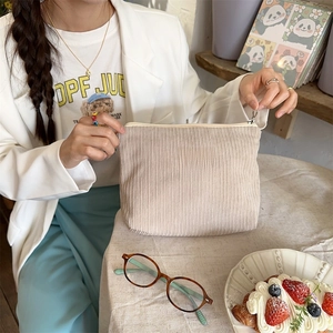 Detail of beige corduroy toiletry bag showing textured fabric and sora ka beauté label