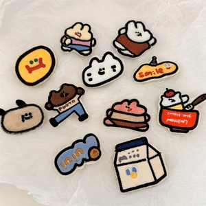 Detail view of 11 assorted cartoon embroidered patches with cute animal and object designs