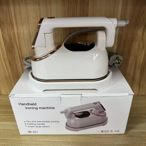 Detail view of foldable handle and golden nozzle on a portable white steam iron