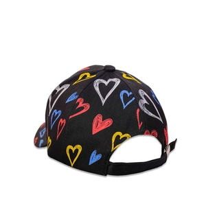 Detail of adjustable strap and metal buckle on black baseball cap with heart patterns