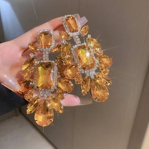 Macro close-up of amber crystal drop earrings with sparkling rhinestones in vintage style