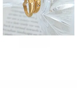Close-up of gold-plated rings with smooth finish and starburst engraved zircon detail
