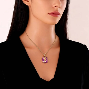 Close-up of purple enamel flower pendant with golden chain worn on a model necklace
