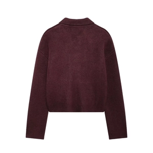 Détail à plat d'un gilet en tricot bordeaux avec col à revers et fermeture éclair